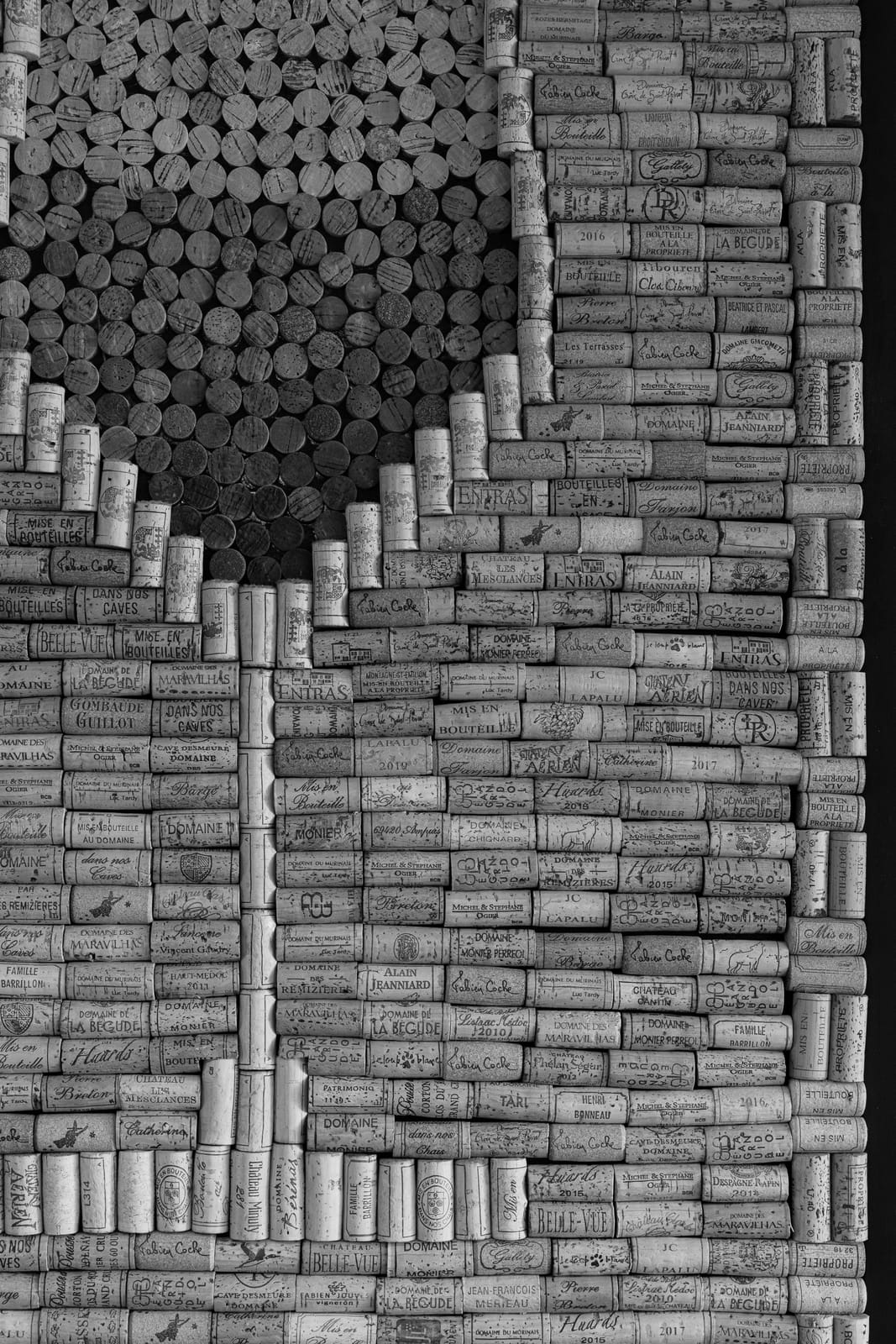 Composition en noir et blanc de bouchons de vins français dans le décor d'À Côté
